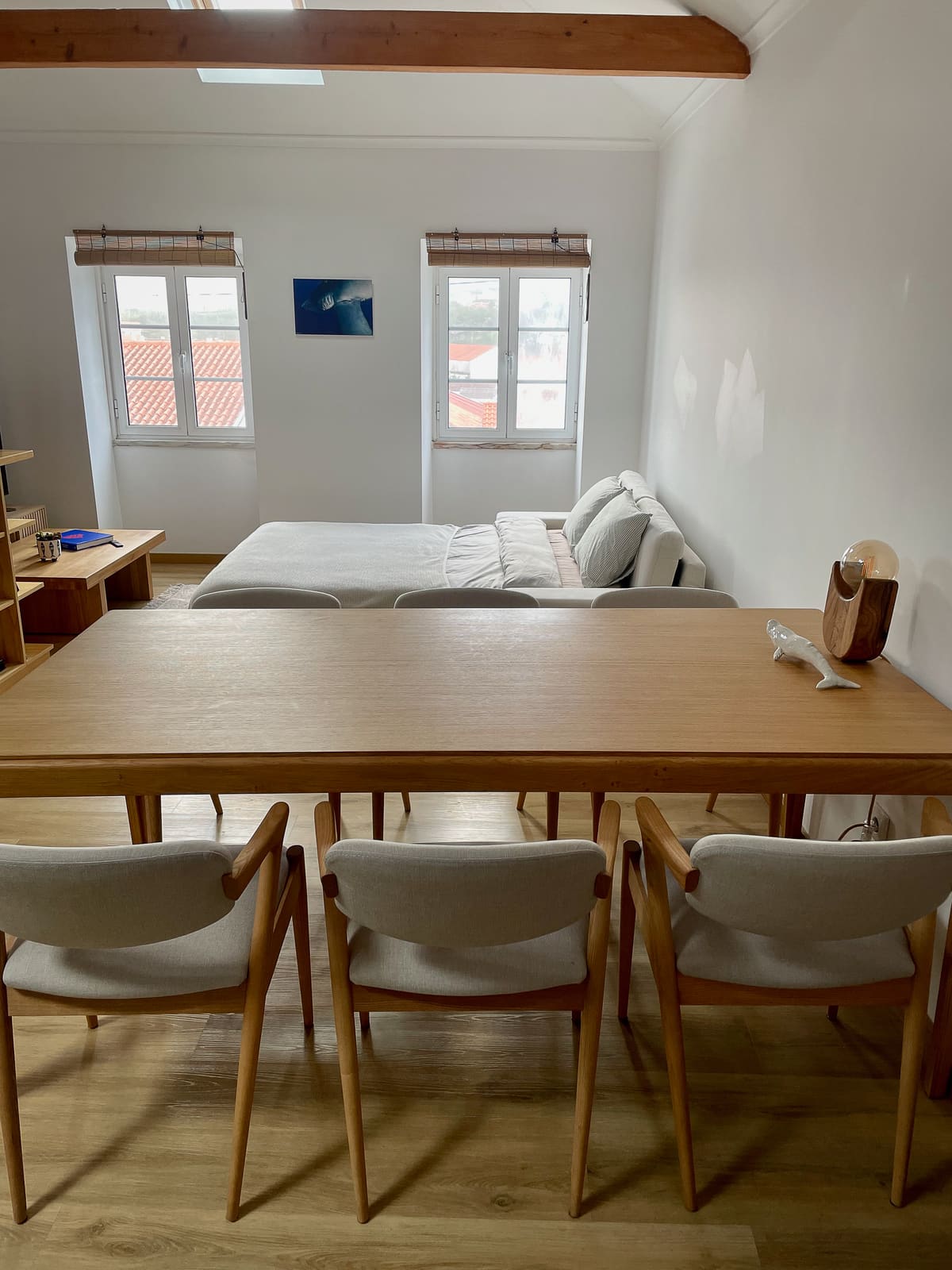 Open-plan living and dining level at Casa Tarapacana with sofa, wooden dining table, and bright windows