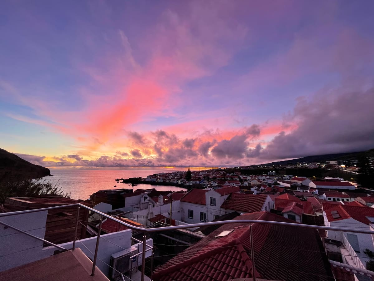 Sunset over Horta rooftops and the harbour from above Porto Pim
